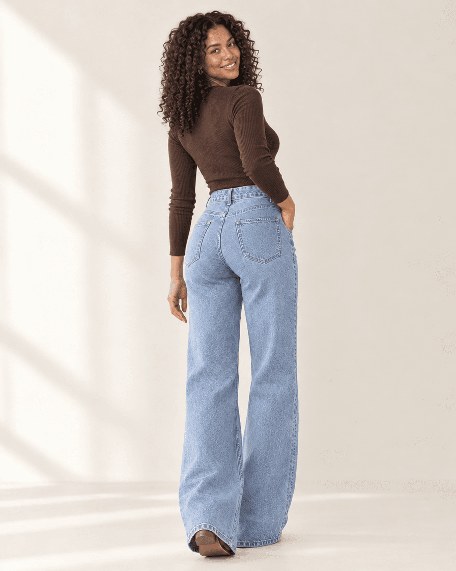 Model in light wash Curve Jeans at a studio shoot, three-quarter back view showing the lift